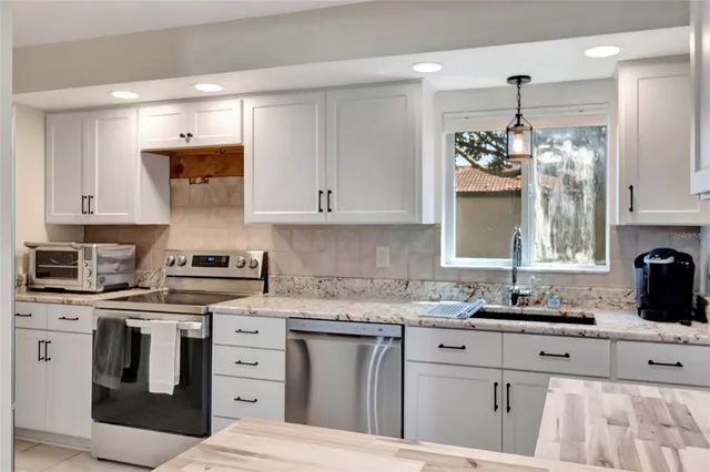 a kitchen with white cabinets and stainless steel appliances