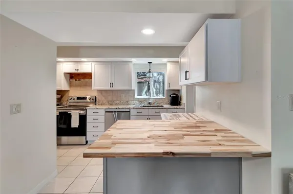 a kitchen with granite countertop a sink and stainless steel appliances