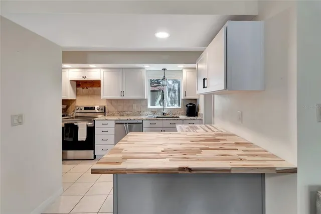 a kitchen with granite countertop a sink and stainless steel appliances