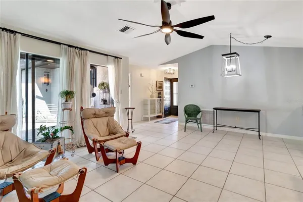 a living room with furniture a chandelier and a window