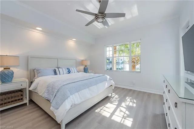 a bedroom with a bed chandelier and a window