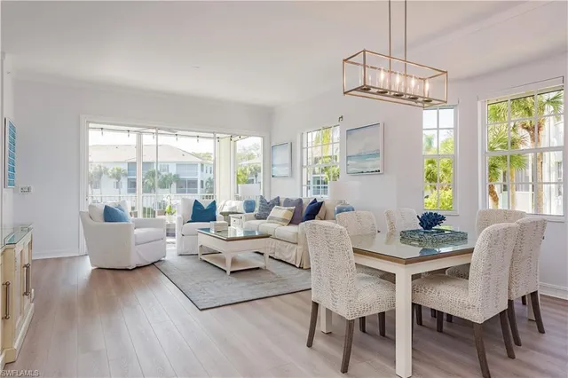 a living room with furniture dining table and a chandelier
