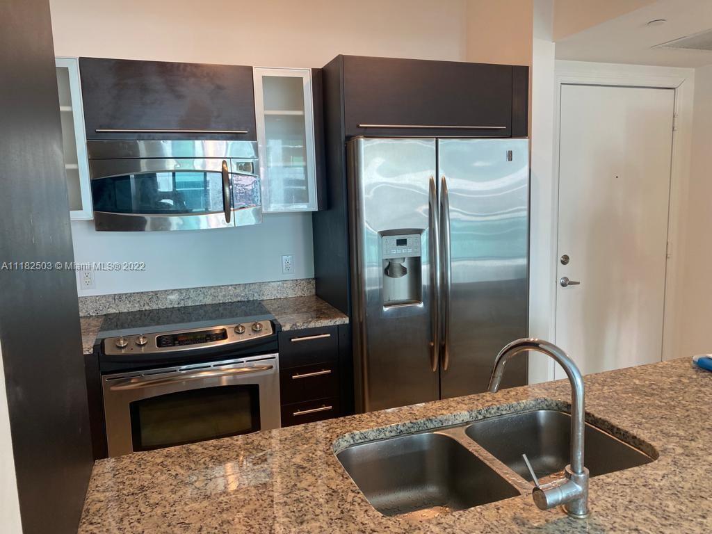 950 Brickell Bay Drive, Unit 602 Miami, FL 33131 - Photo 8 of 16 a kitchen with a refrigerator and a sink