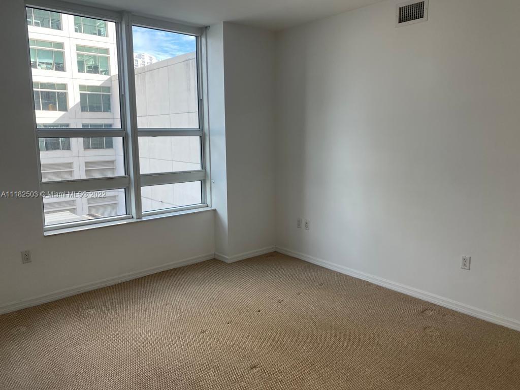 950 Brickell Bay Drive, Unit 602 Miami, FL 33131 - Photo 10 of 16 an empty room with a window
