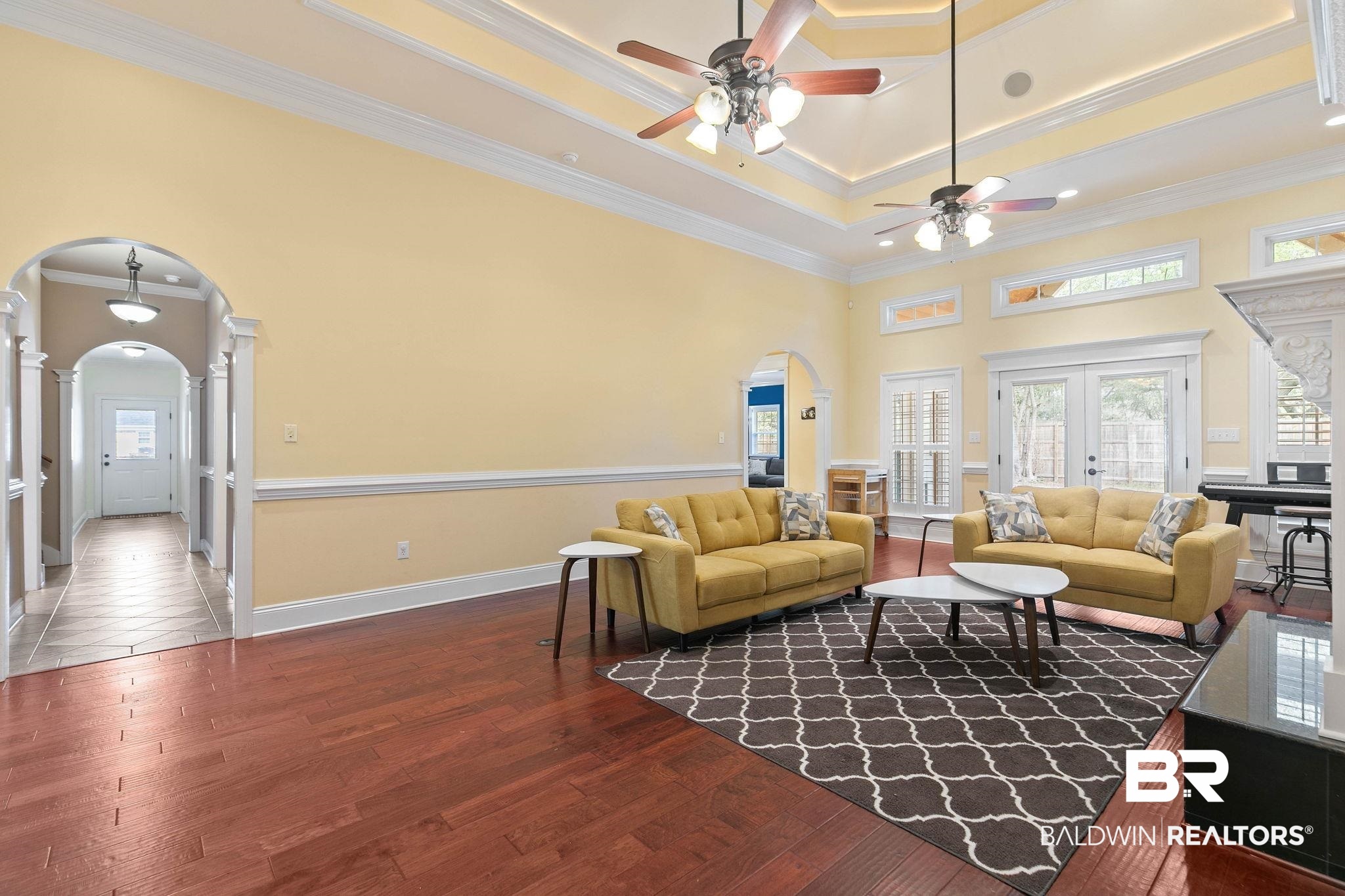 3668 Claridge Road North Mobile, AL 36608 - Photo 28 of 100 Living area with arched walkways, dark wood-style flooring, crown molding, french doors, and a ceiling fan