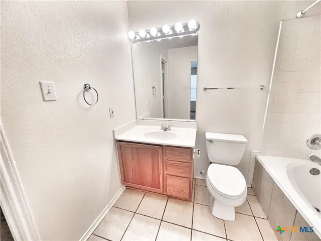 a bathroom with a toilet a sink a mirror and vanity