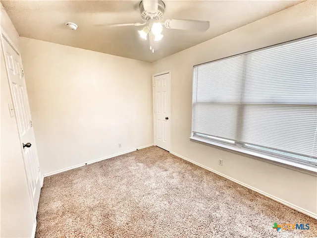 a view of empty room with ceiling fan