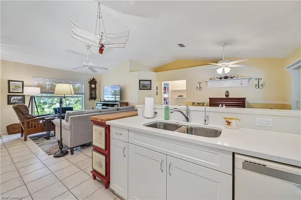 a kitchen with a sink a counter space appliances and cabinets