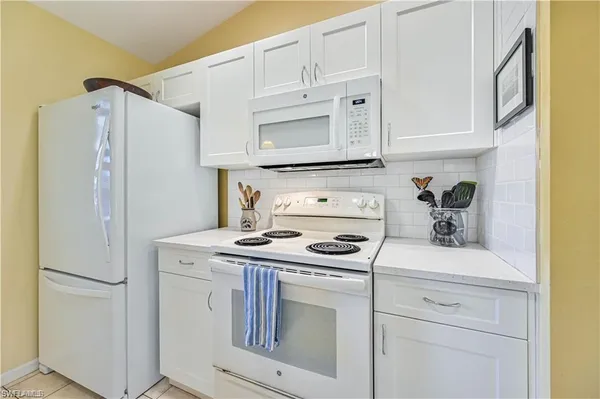 a kitchen with stainless steel appliances white cabinets and white appliances