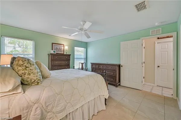 a spacious bedroom with a bed and dresser with the floor