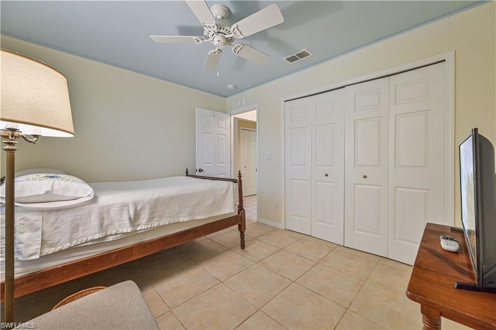 18546 Violet Road Fort Myers, FL 33967 - Photo 24 of 38 a spacious bedroom with a bed and a chandelier