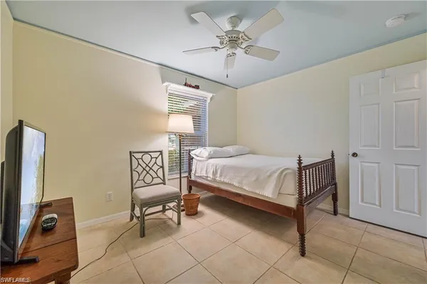 a bedroom with a bed a chair and a chandelier