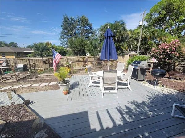 a view of a patio with table and chairs potted plants with wooden floor and fence