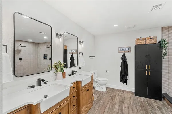 a bathroom with a double vanity sink toilet and shower