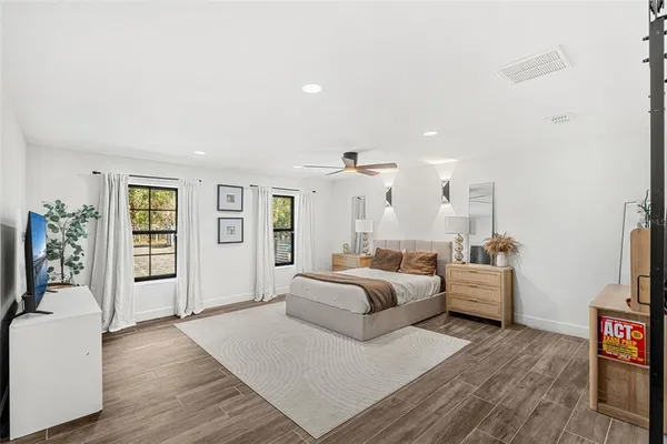 a large bedroom with a bed and wooden floor