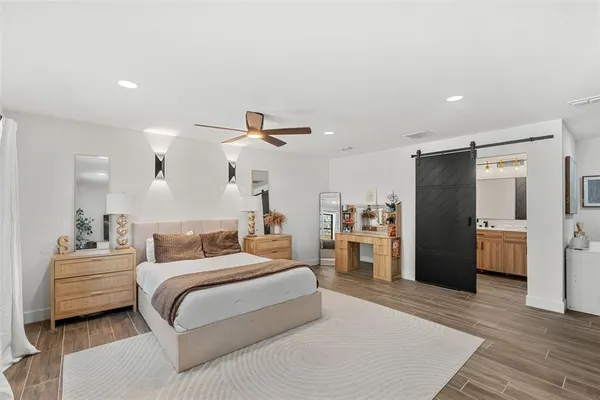 a bedroom with a bed and a refrigerator