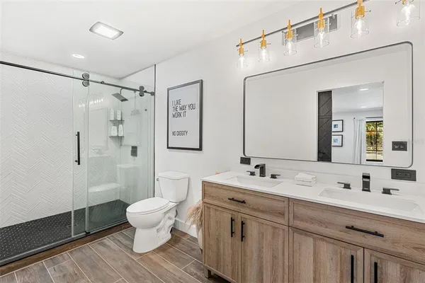 a bathroom with a double vanity sink mirror and toilet