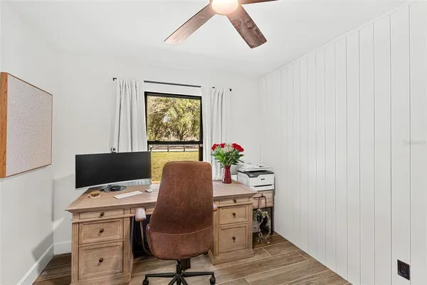 a view of a workspace with furniture and a window