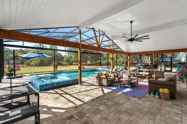 a living room with patio furniture and a floor to ceiling window