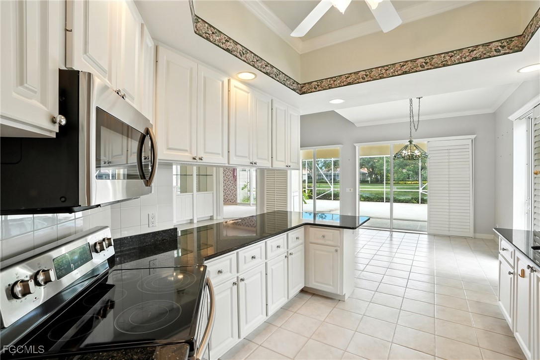 4017 Isla Ciudad Court Naples, FL 34109 - Photo 11 of 36 a kitchen with a stove a sink and a refrigerator