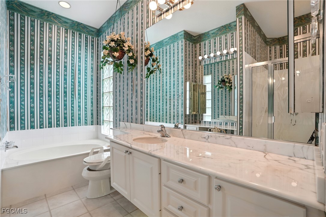 4017 Isla Ciudad Court Naples, FL 34109 - Photo 19 of 36 a bathroom with a double vanity sink toilet and shower