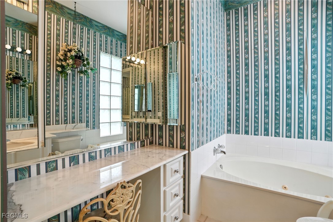 4017 Isla Ciudad Court Naples, FL 34109 - Photo 20 of 36 a bathroom with a sink and a large mirror