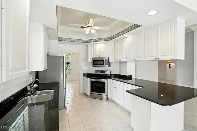 a kitchen with granite countertop a sink stainless steel appliances and cabinets