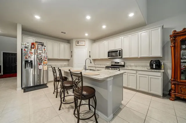 a kitchen with a refrigerator and a stove top oven