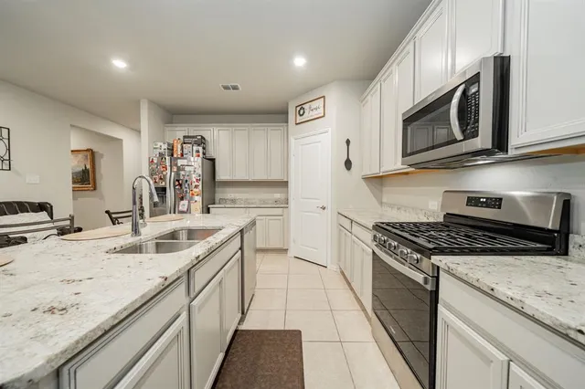 a kitchen with stainless steel appliances granite countertop a sink stove and microwave