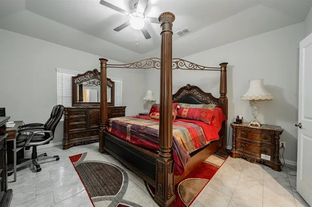 a bedroom with a bed a dresser and chair