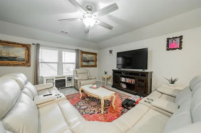 a living room with furniture a flat screen tv and a fireplace