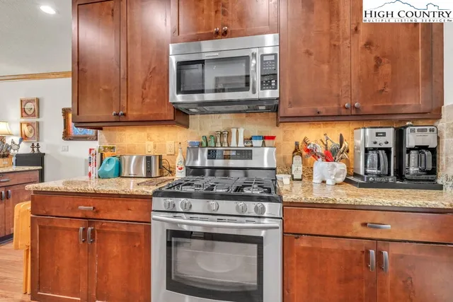 a kitchen with stainless steel appliances granite countertop wooden cabinets stove top oven and sink