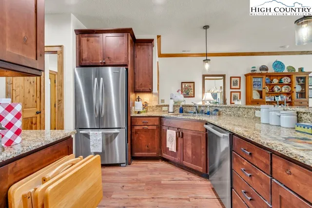 a kitchen with stainless steel appliances granite countertop a refrigerator and a sink