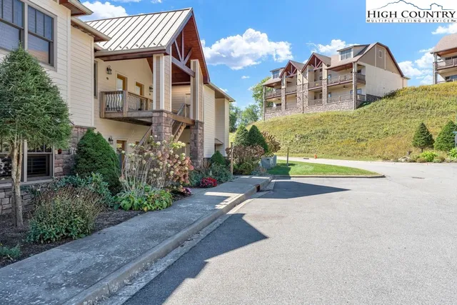 a view of a building with a yard and potted plants