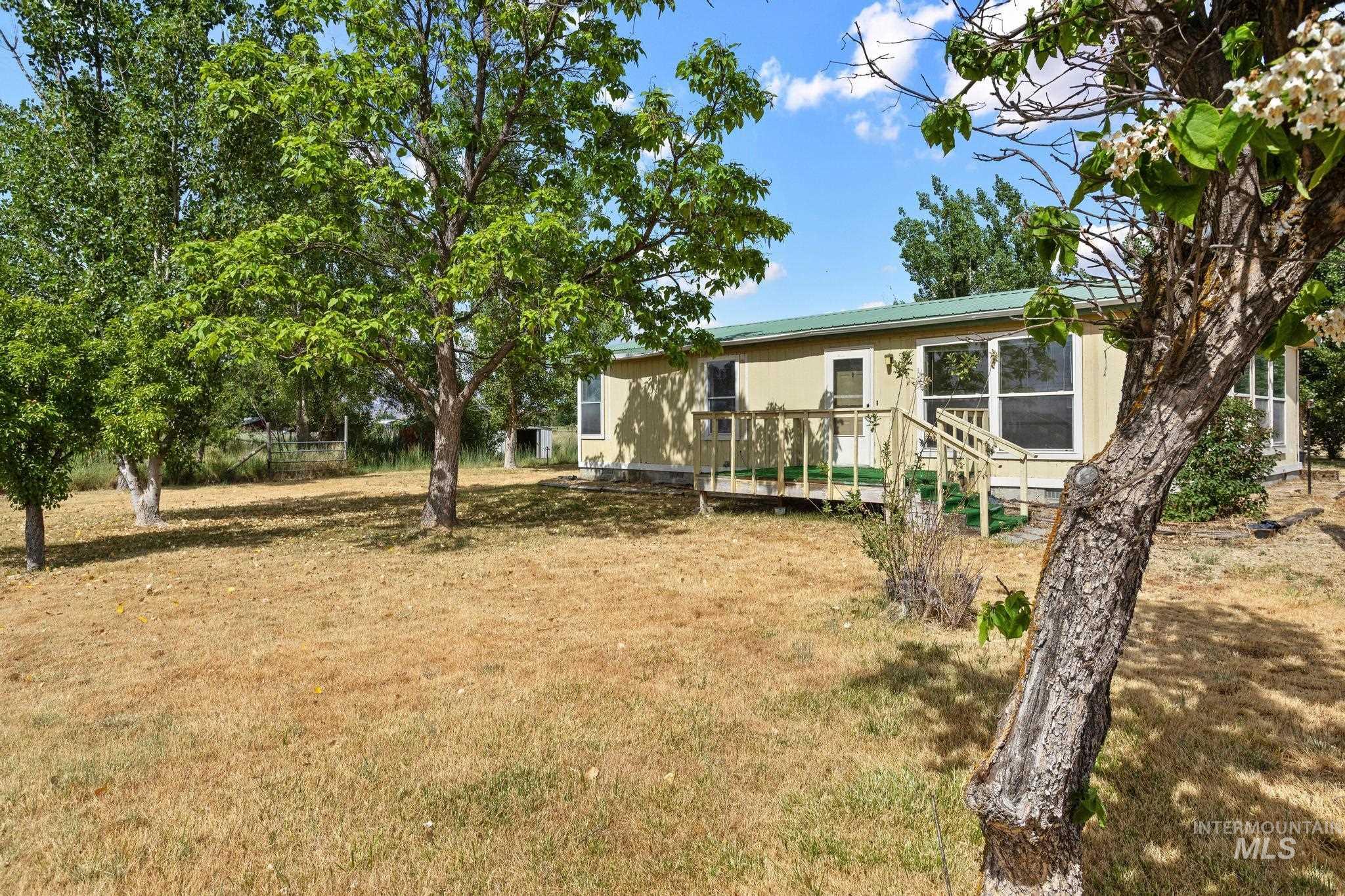 3680 South Mill Road Emmett, ID 83617 - Photo 6 of 38 Ranch-style exterior with light-toned siding and a green roof