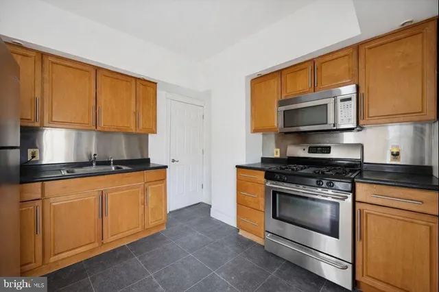 a kitchen with stainless steel appliances granite countertop a stove microwave and sink