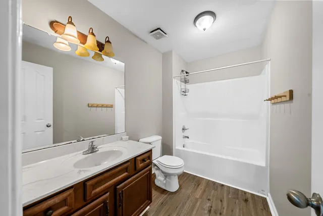 a bathroom with a granite countertop sink toilet and shower