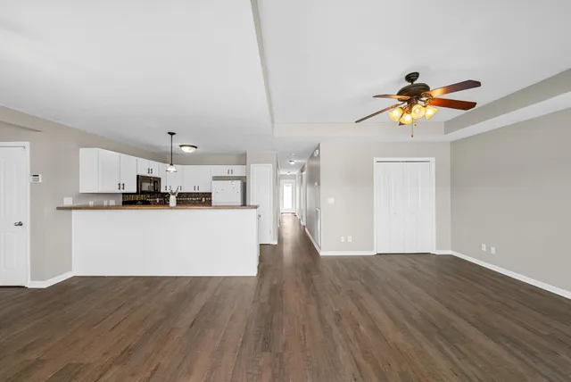 a view of a kitchen with wooden floor and a ceiling fan