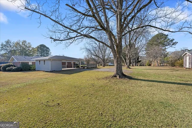 a view of backyard with wooden fence
