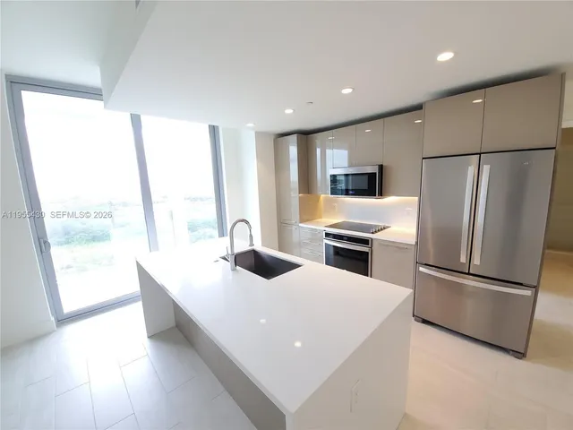 a kitchen with sink refrigerator and microwave