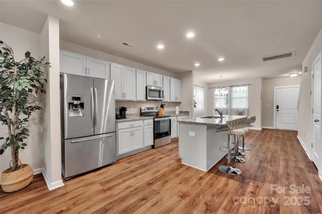 a kitchen with a refrigerator a sink and cabinets