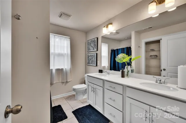 a bathroom with a double vanity sink toilet and shower