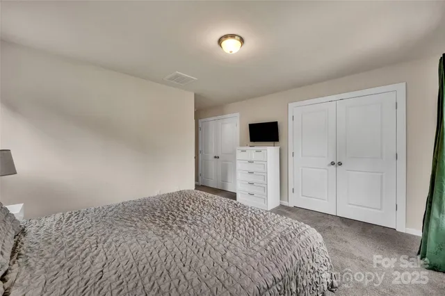 a bedroom with a bed and a view of kitchen