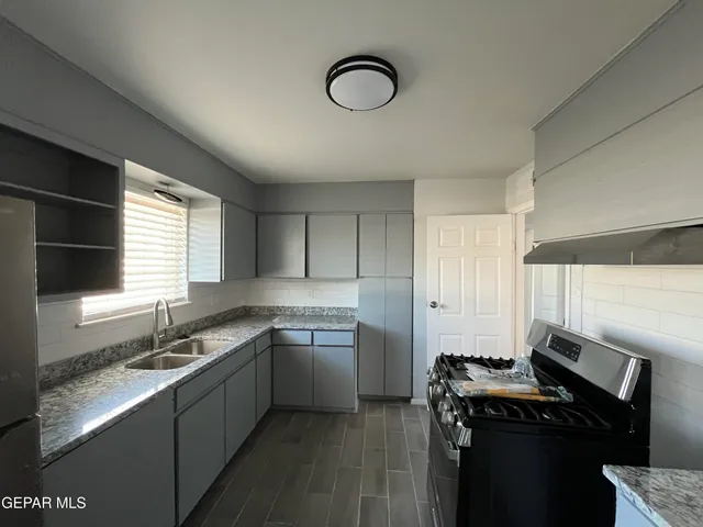 a kitchen with cabinets appliances and a window