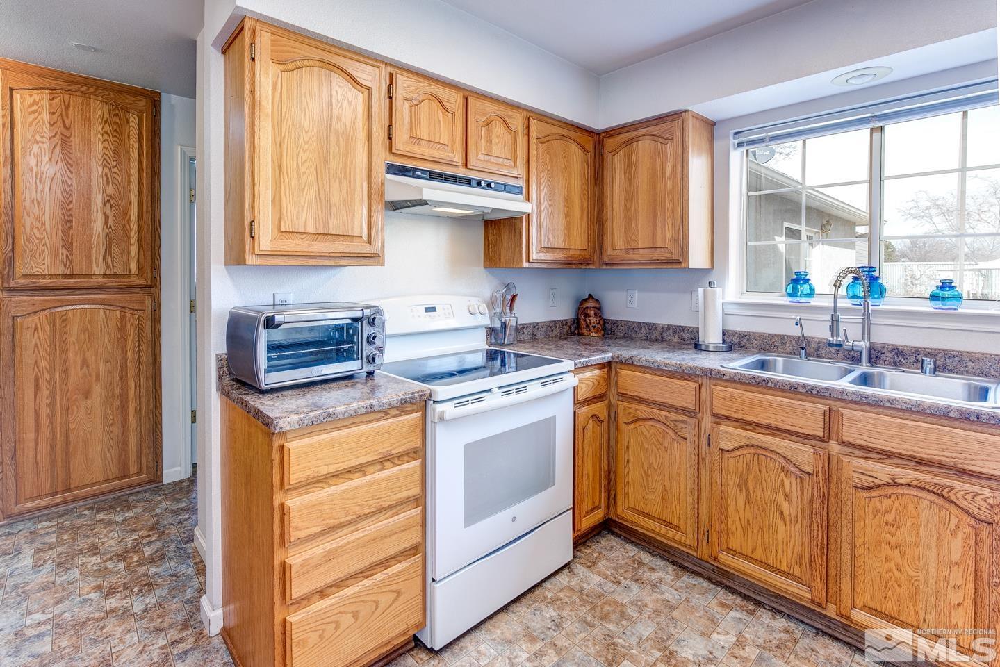 4170 Bottom Road Fallon, NV 89406 - Photo 11 of 38 a kitchen with stainless steel appliances granite countertop a stove a sink and a refrigerator