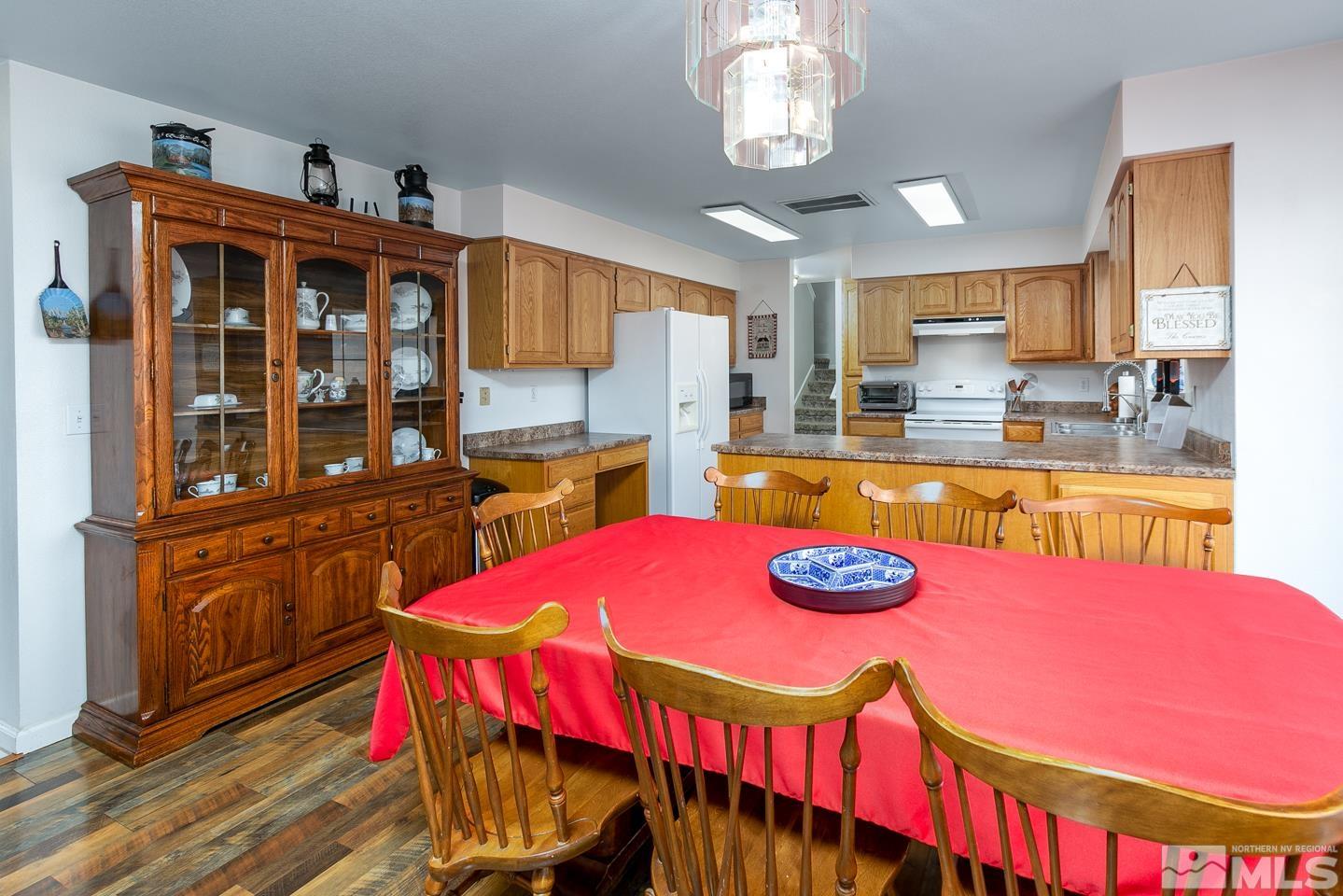 4170 Bottom Road Fallon, NV 89406 - Photo 9 of 38 a kitchen with stainless steel appliances kitchen island granite countertop a dining table and chairs with wooden floor
