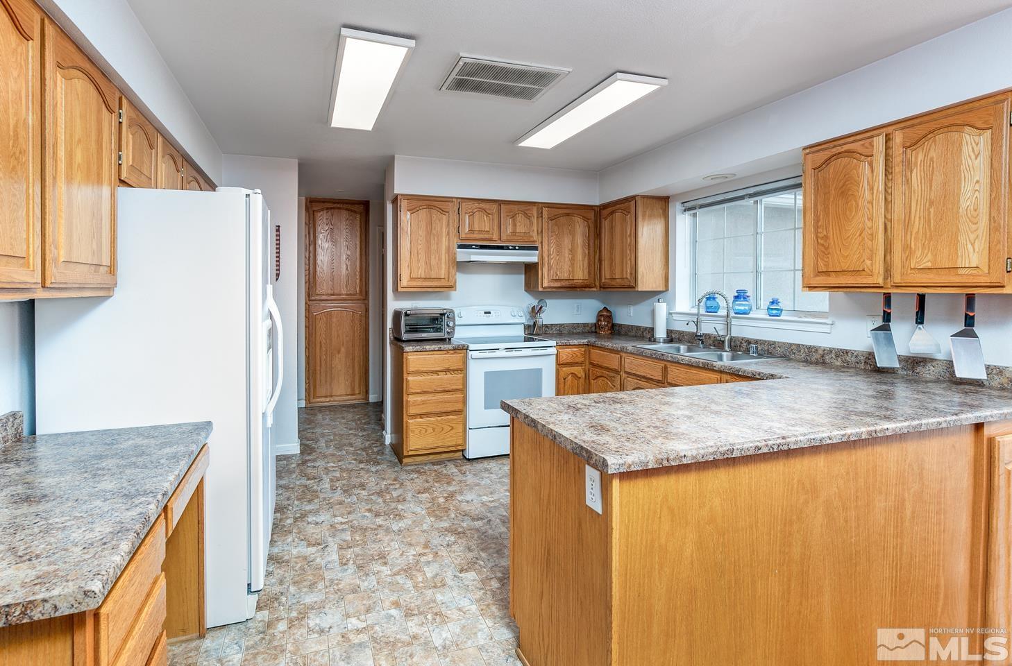 4170 Bottom Road Fallon, NV 89406 - Photo 10 of 38 a kitchen with granite countertop a sink a counter top space and cabinets