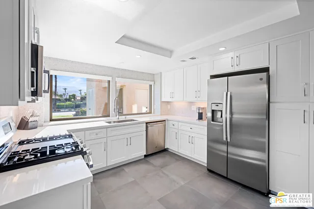 a kitchen with a stove a sink and a refrigerator