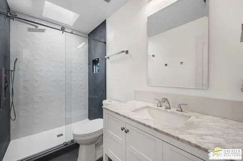 a bathroom with a granite countertop sink toilet and shower