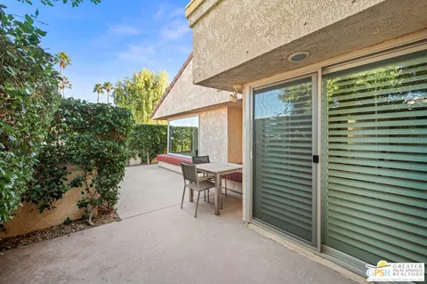 a view of a patio with a table and chairs and potted plants